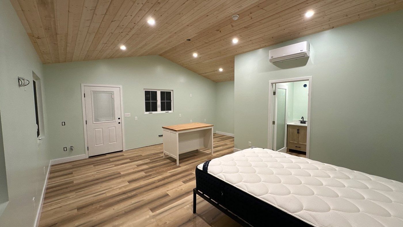 Open ADU interior with vaulted wood plank ceiling