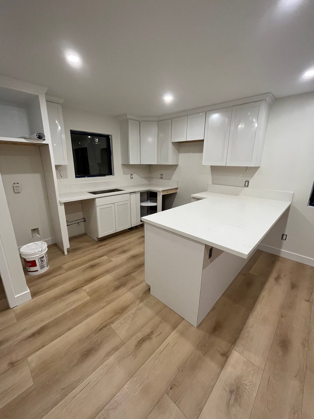 Finished ADU kitchen with white cabinets and quartz counters