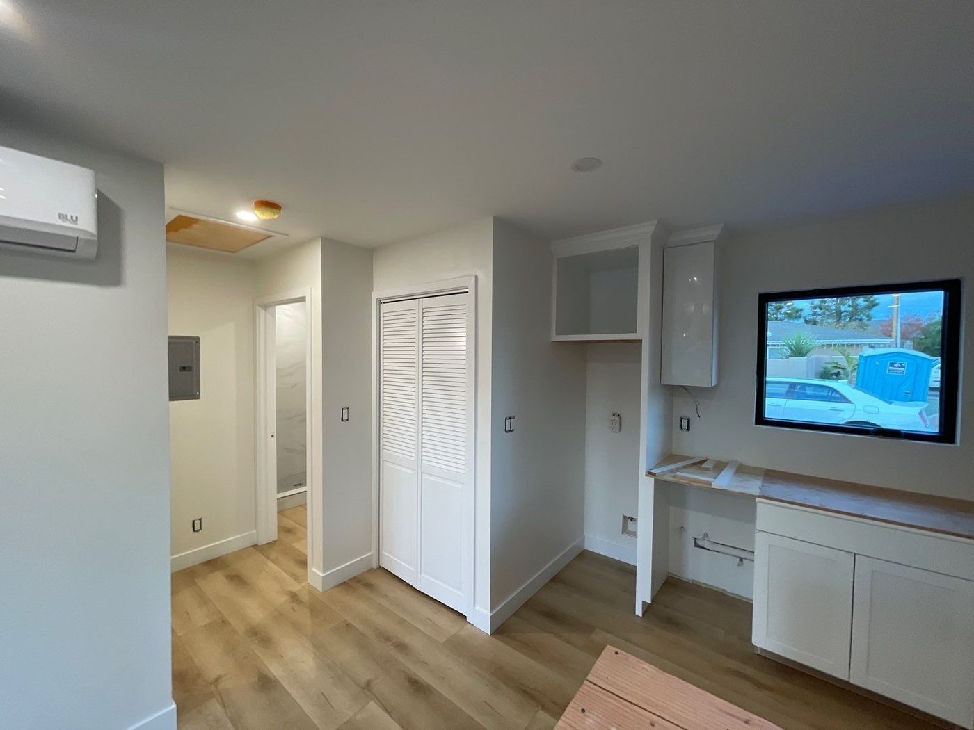 ADU interior with closet, built-in desk, and wood-look flooring