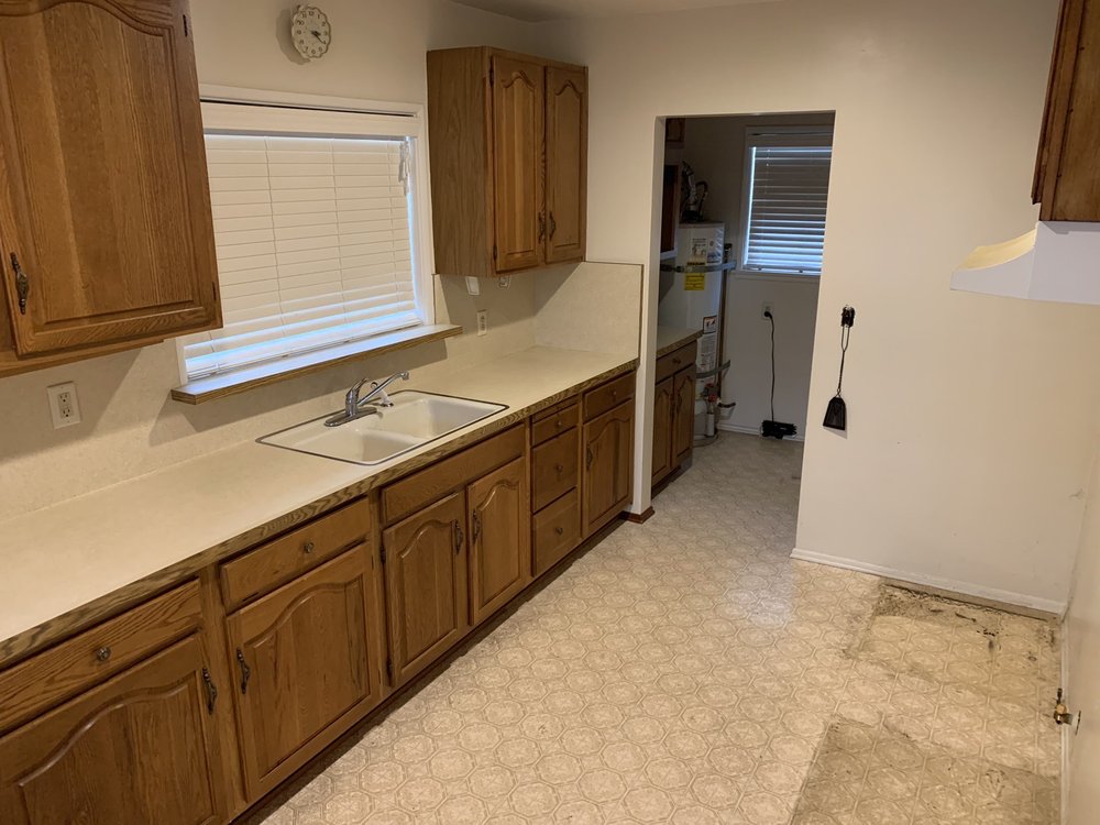 Dated kitchen before remodel, with oak cabinets and a cramped galley layout