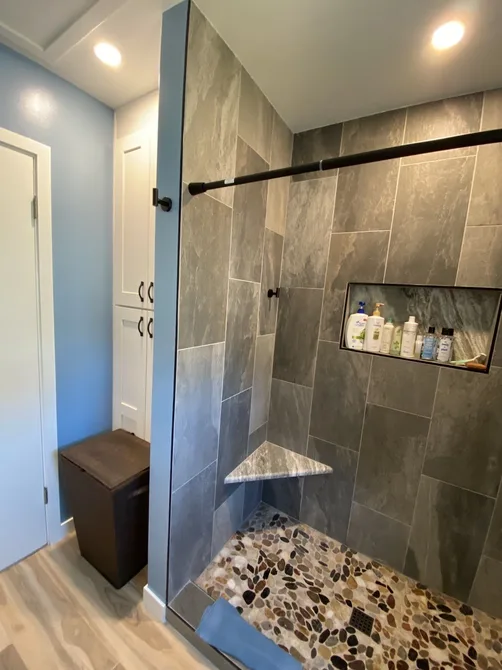 Walk-in shower remodel in the South Bay with slate tile, glass panel, and pebble stone floor by Ten Eight Renovations